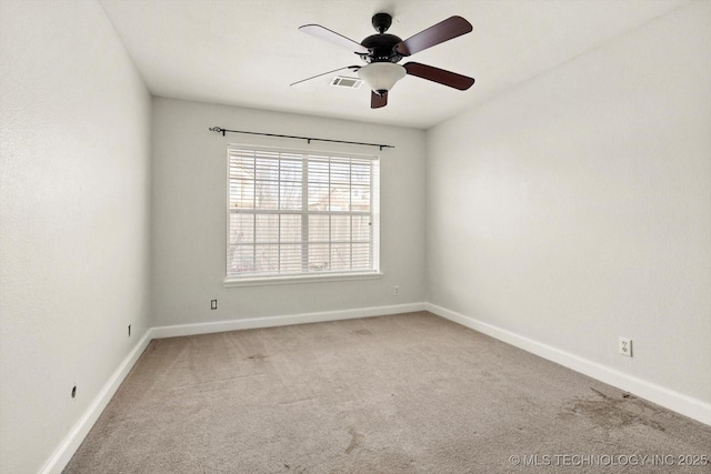 carpeted empty room featuring visible vents, baseboards, and a ceiling fan