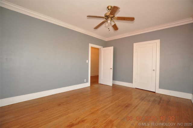 unfurnished room featuring ceiling fan, crown molding, baseboards, and wood finished floors