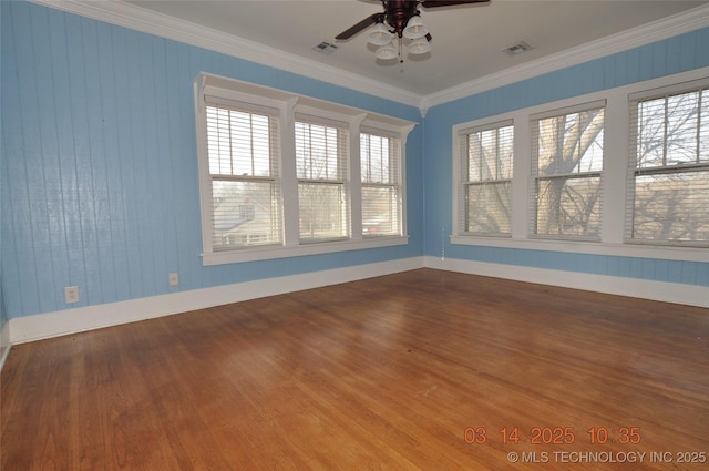 spare room with crown molding, wood finished floors, visible vents, and ceiling fan