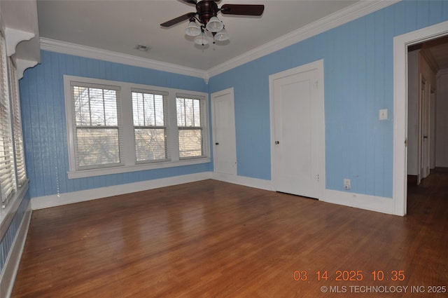 spare room with baseboards, wood finished floors, ornamental molding, and a ceiling fan