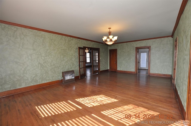 unfurnished room with wood finished floors, a chandelier, ornamental molding, and wallpapered walls