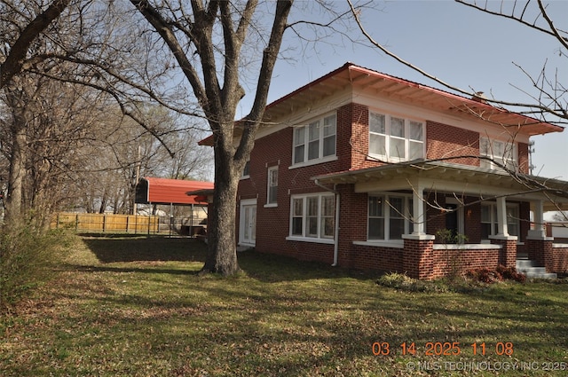 view of home's exterior featuring covered porch, a yard, fence, and brick siding