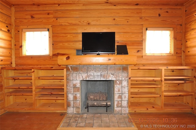 living room featuring log walls, wood finished floors, and a fireplace