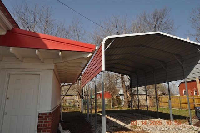 exterior space featuring a carport and fence