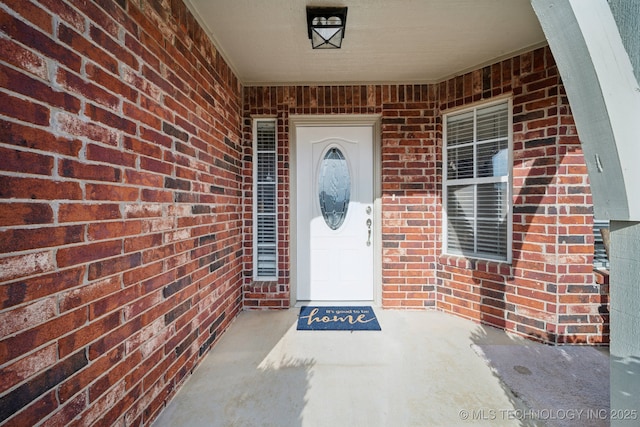 doorway to property featuring brick siding