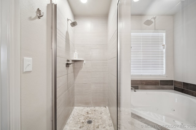 full bath featuring a jetted tub and a stall shower