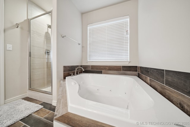 bathroom featuring a tub with jets and a stall shower