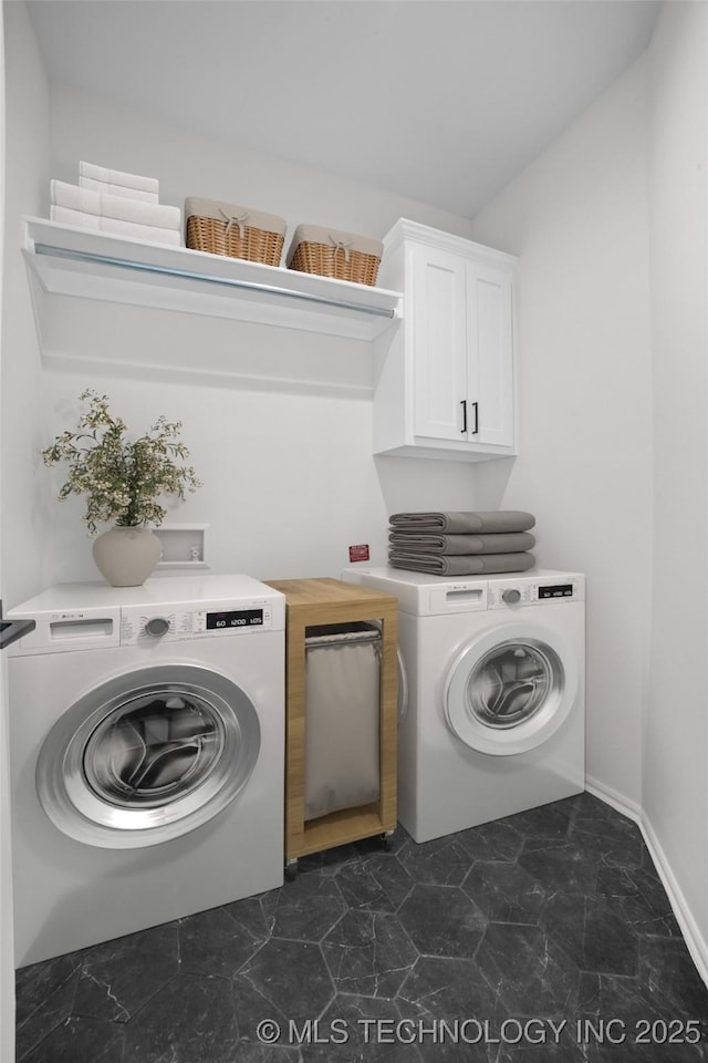 washroom with washer and dryer, baseboards, and cabinet space