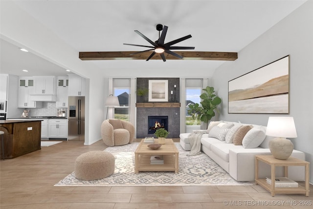 living room featuring a ceiling fan, light wood-style flooring, a fireplace, recessed lighting, and beamed ceiling