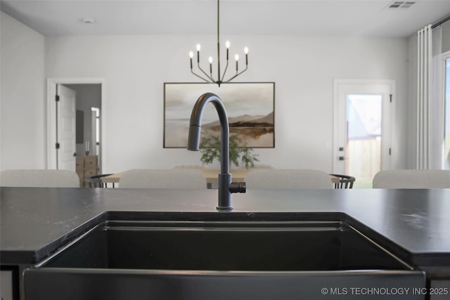 room details featuring a sink, visible vents, dark countertops, and a chandelier