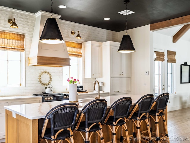 26 Boardwalk, Carlton Landing, OK 74432 - kitchen with decorative backsplash, a breakfast bar area, light wood finished floors, a kitchen island with sink, and recessed lighting