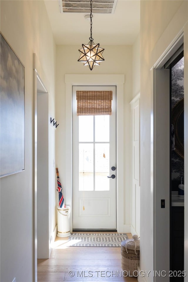 doorway to outside featuring visible vents and wood-type flooring