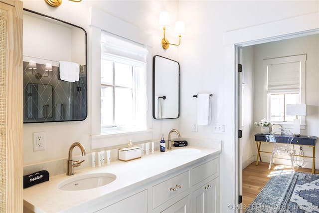 full bathroom with double vanity, wood finished floors, and a sink