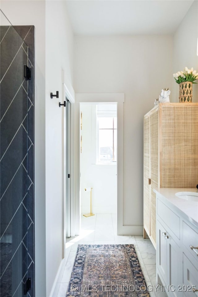 bathroom with walk in shower, marble finish floor, and vanity