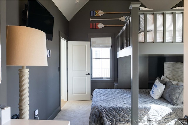 carpeted bedroom with baseboards and lofted ceiling