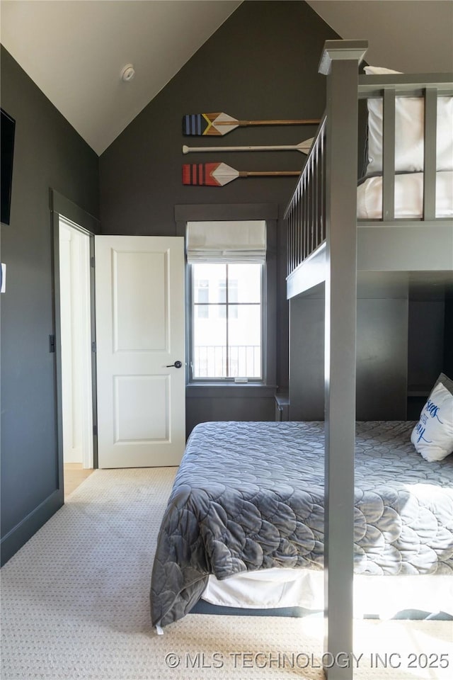 carpeted bedroom featuring vaulted ceiling and baseboards