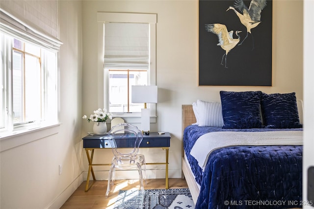 bedroom with baseboards and wood finished floors