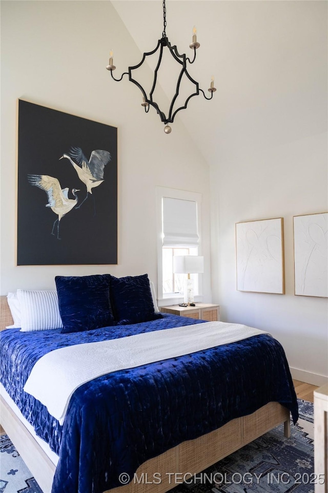 bedroom featuring baseboards, wood finished floors, and vaulted ceiling