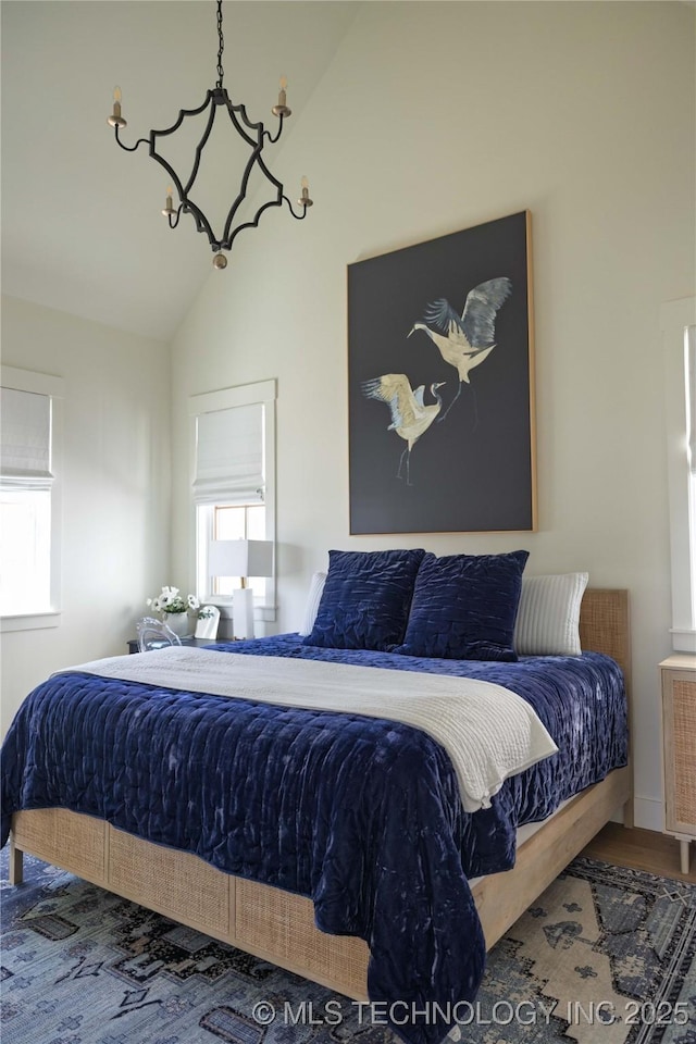 bedroom with vaulted ceiling, radiator heating unit, wood finished floors, and a chandelier