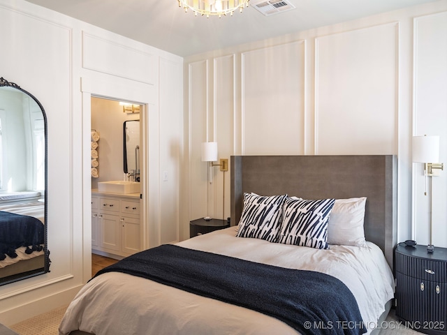26 Boardwalk, Carlton Landing, OK 74432 - bedroom featuring a chandelier, ensuite bathroom, and a sink