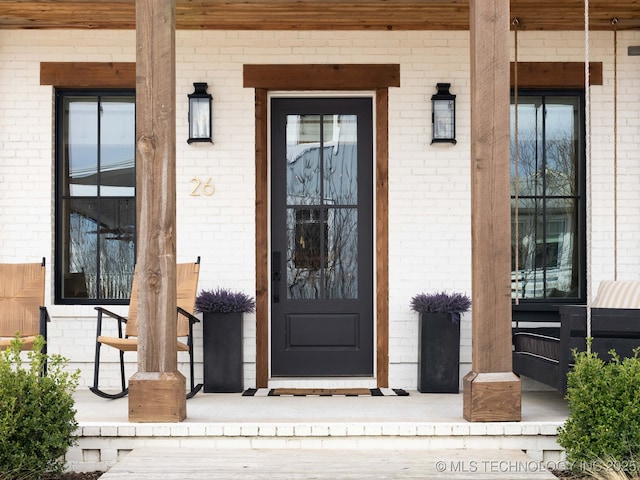 26 Boardwalk, Carlton Landing, OK 74432 - property entrance with a porch and brick siding