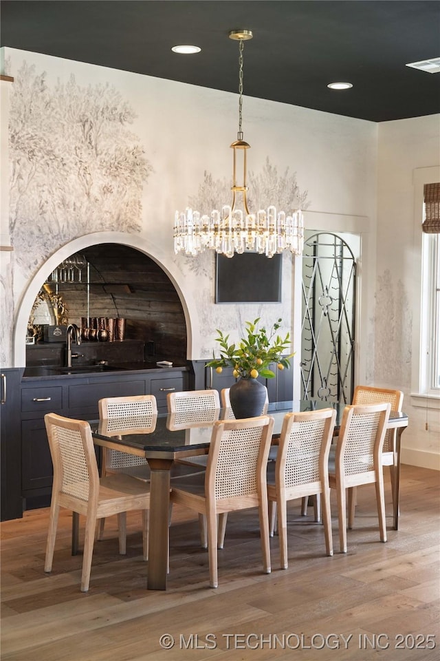 dining room with a notable chandelier and light wood finished floors