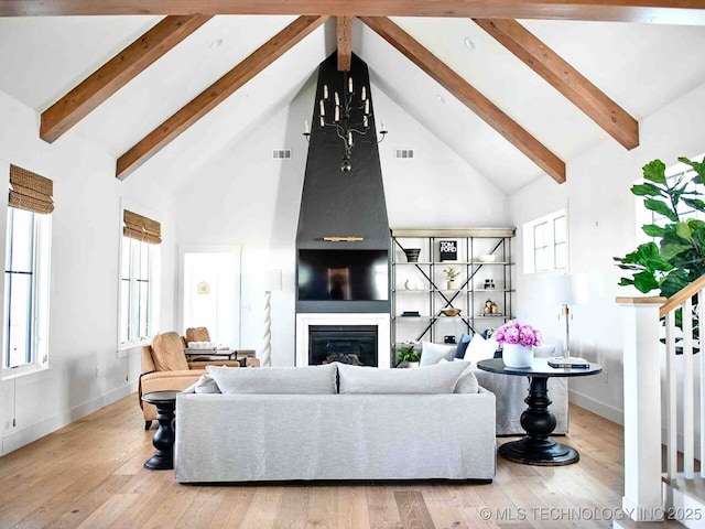 26 Boardwalk, Carlton Landing, OK 74432 - living area featuring high vaulted ceiling, beam ceiling, a glass covered fireplace, baseboards, and wood finished floors