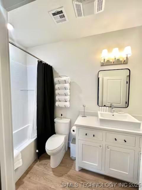 full bath featuring visible vents, toilet, shower / bath combo, and vanity