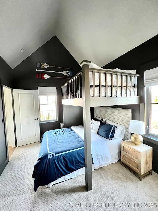 carpeted bedroom with lofted ceiling