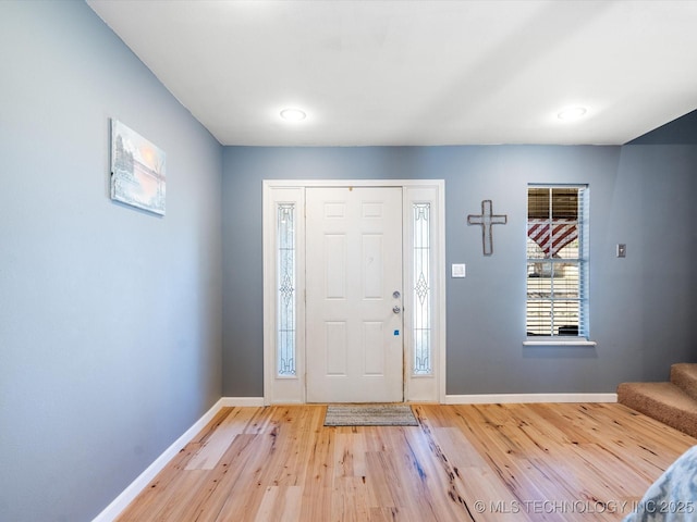 foyer with light wood finished floors, stairs, and baseboards