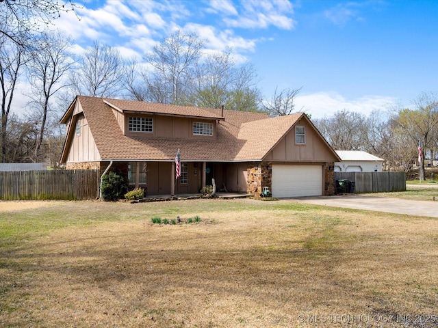 traditional-style home featuring a front lawn, fence, board and batten siding, and driveway