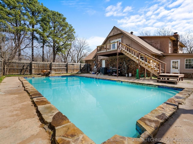 view of pool with stairway, a deck, a fenced backyard, and a patio area