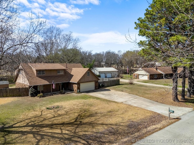 view of front of property featuring board and batten siding, driveway, a front lawn, and fence