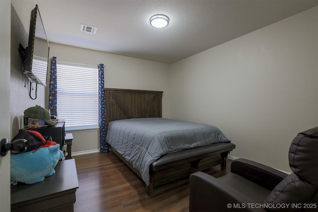 bedroom with visible vents, dark wood-type flooring, and baseboards