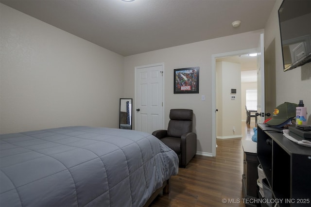 bedroom featuring dark wood-type flooring and baseboards