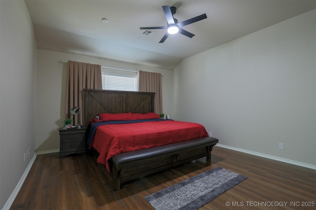 bedroom featuring visible vents, baseboards, wood finished floors, and vaulted ceiling