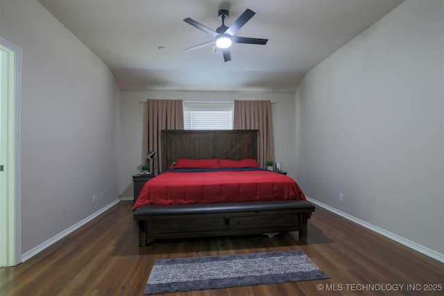 bedroom featuring baseboards, wood finished floors, and vaulted ceiling