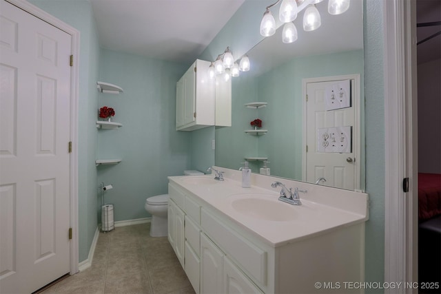 bathroom with tile patterned floors, double vanity, baseboards, and a sink