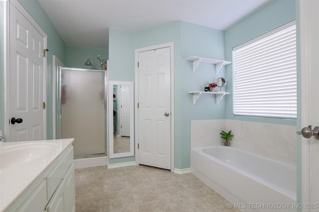 bathroom featuring a bath, tile patterned floors, a stall shower, and vanity