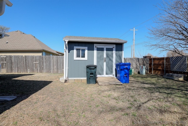 rear view of property with an outdoor structure, a yard, a fenced backyard, and a shed