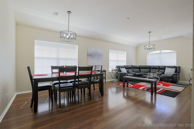 dining area with baseboards, an inviting chandelier, dark wood-style floors, and vaulted ceiling