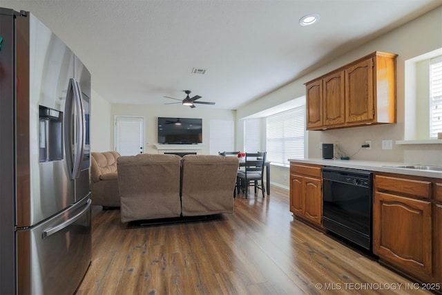 kitchen featuring dishwasher, light countertops, stainless steel fridge, a ceiling fan, and dark wood-style flooring