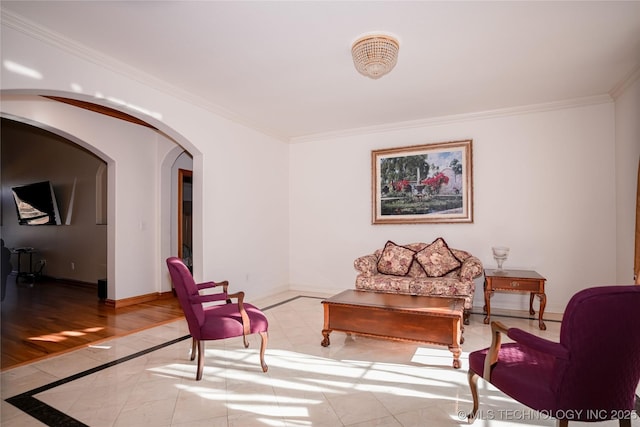 sitting room featuring baseboards, arched walkways, and crown molding