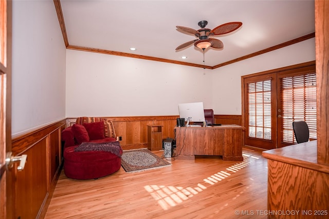 office area with a wainscoted wall, light wood-style floors, a ceiling fan, and ornamental molding