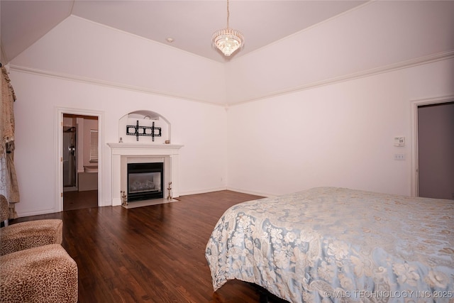 bedroom featuring a fireplace with flush hearth and wood finished floors