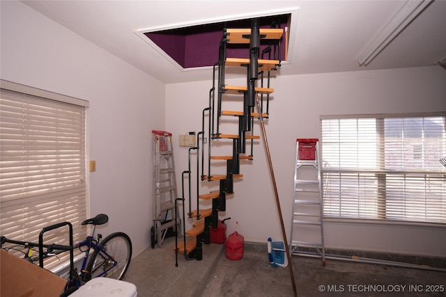 staircase featuring concrete flooring