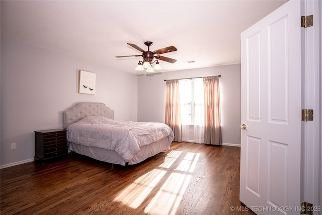 bedroom with ceiling fan, visible vents, baseboards, and dark wood finished floors