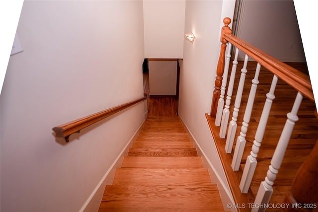 stairs with wood finished floors and baseboards