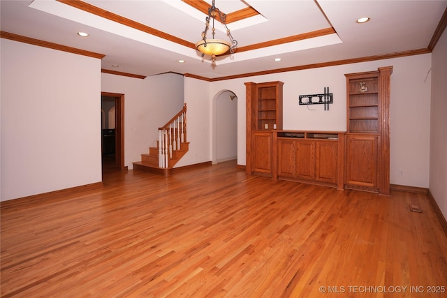 unfurnished room featuring stairway, a tray ceiling, light wood-style flooring, a skylight, and recessed lighting