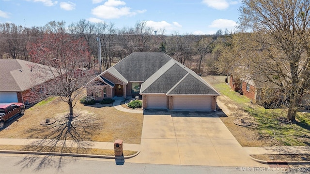 view of front of property with a garage, brick siding, concrete driveway, and a shingled roof